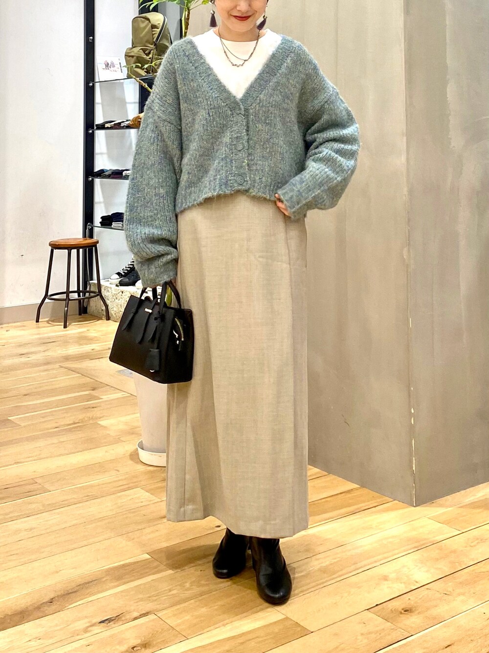 ブルー系のカーディガン/ボレロ、ホワイト系のTシャツ/カットソー、ベージュ系のスカートを着用したレディースの秋コーディネートの4枚目の写真