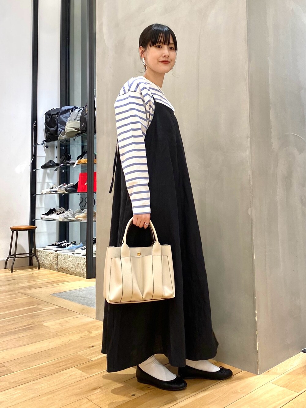 ブルー系のTシャツ/カットソー、ブラック系のワンピース、ホワイト系のトートバッグを着用したレディースの春コーディネートの2枚目の写真