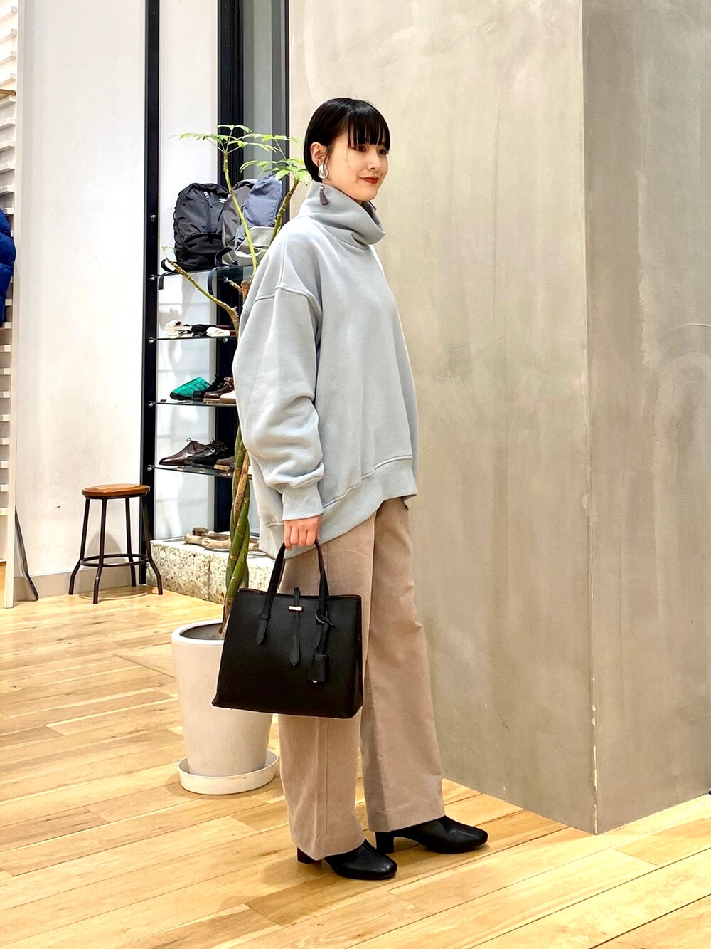 ブルー系のスウェット、ベージュ系のその他パンツ、ブラック系のトートバッグを着用したレディースの冬コーディネートの3枚目の写真