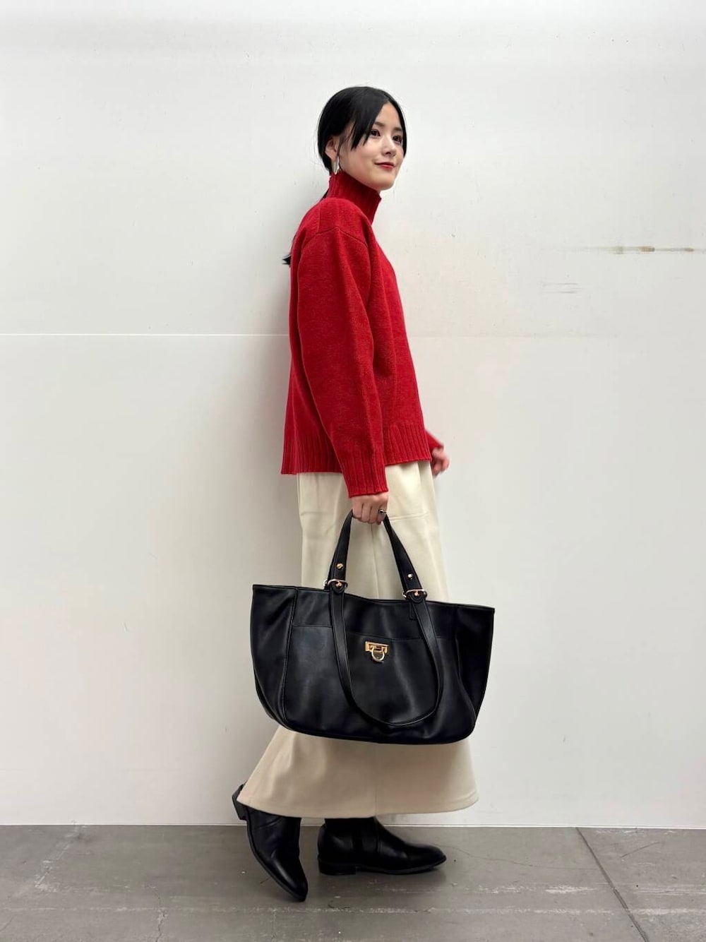 ブラック系のトートバッグ、ブラック系のブーツ、ホワイト系のスカートを着用したレディースの冬コーディネートの2枚目の写真