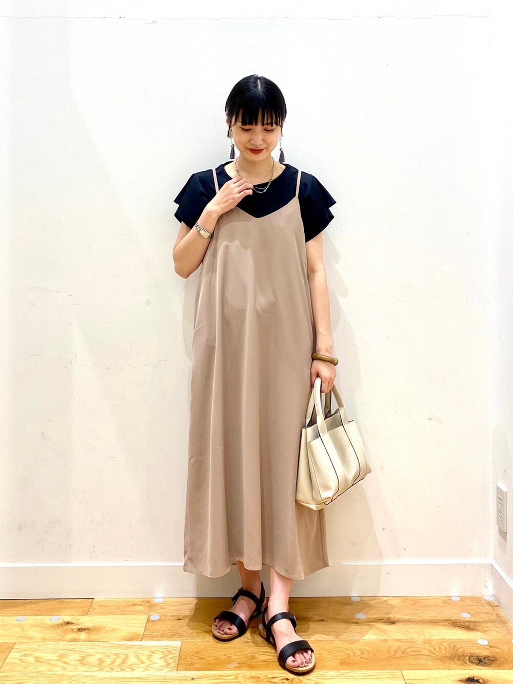 ブラック系のTシャツ/カットソー、ベージュ系のワンピース、ホワイト系のトートバッグを着用したレディースの夏コーディネートの2枚目の写真