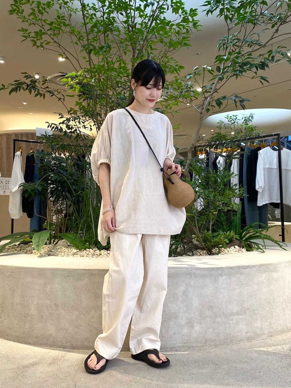 ベージュ系のシャツ/ブラウス、ベージュ系のデニムパンツ、ブラック系のサンダルを着用したレディースの夏コーディネートの2枚目の写真