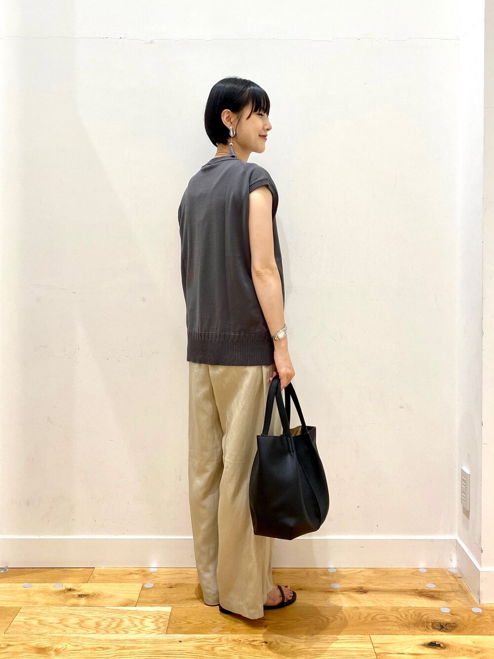 グレー系のニット/セーター、ベージュ系のその他パンツ、ブラック系のトートバッグを着用したレディースの夏コーディネートの3枚目の写真