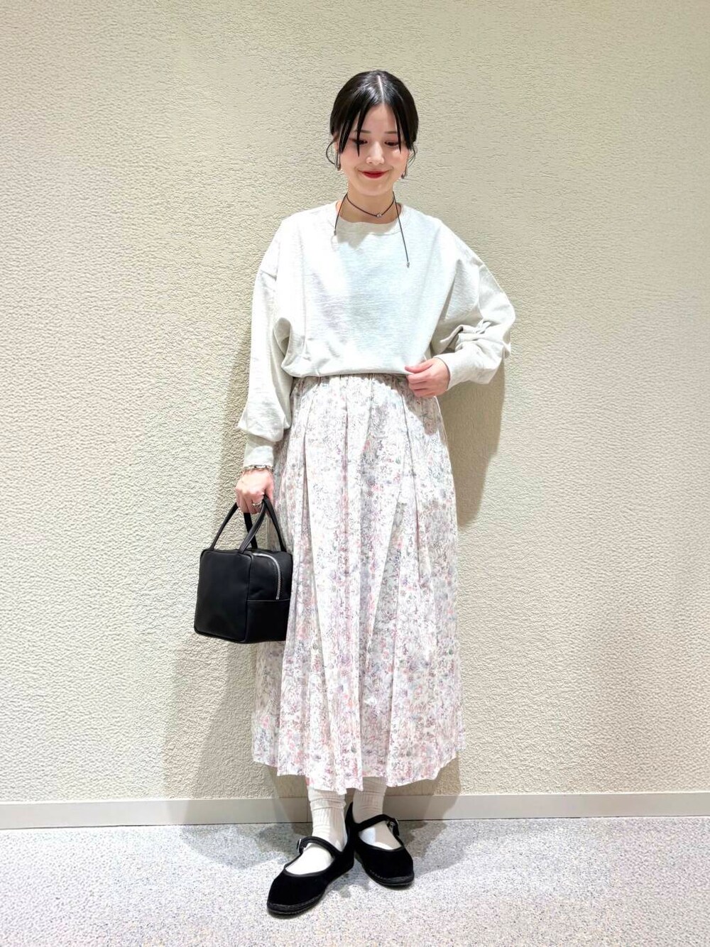 ベージュ系のTシャツ/カットソー、ホワイト系のスカート、ホワイト系のダウンジャケット/コートを着用したレディースの春コーディネートの4枚目の写真