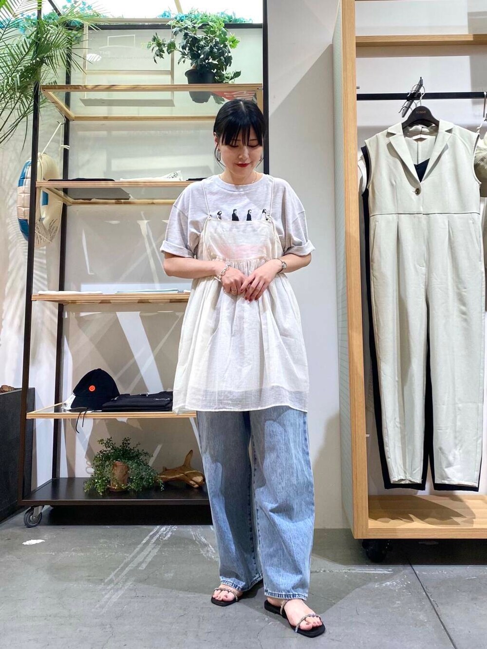 ブルー系のデニムパンツ、グレー系のTシャツ/カットソー、ブラック系のサンダルを着用したレディースの夏コーディネートの4枚目の写真