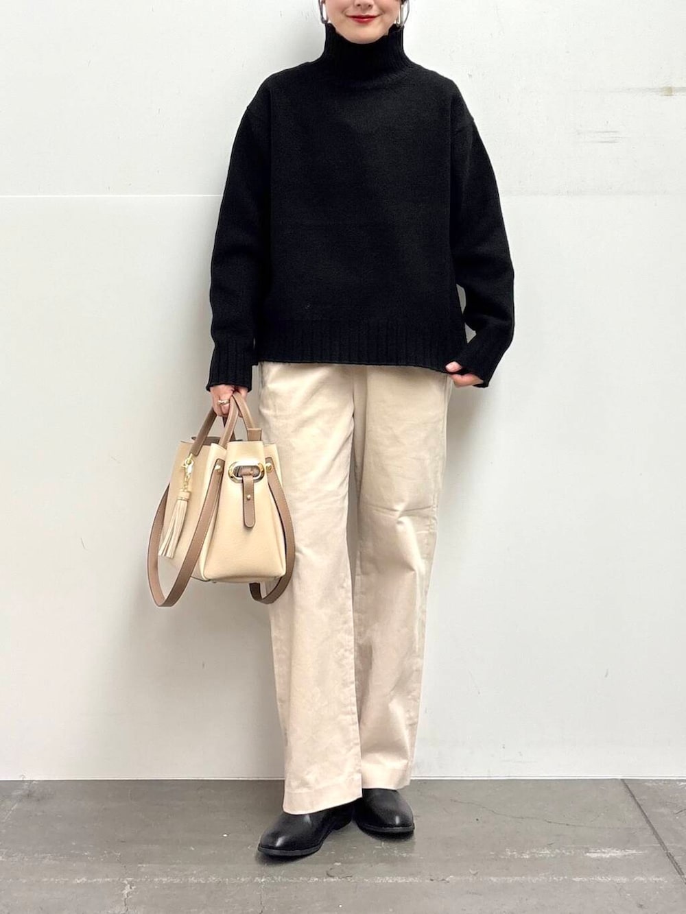 ホワイト系のトートバッグ、ブラック系のブーツ、ホワイト系のその他パンツを着用したレディースの冬コーディネートの4枚目の写真