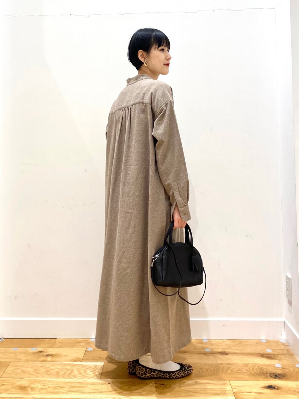 ホワイト系のカーディガン/ボレロ、ベージュ系のワンピース、ブラック系のボストンバッグを着用したレディースの冬コーディネートの5枚目の写真