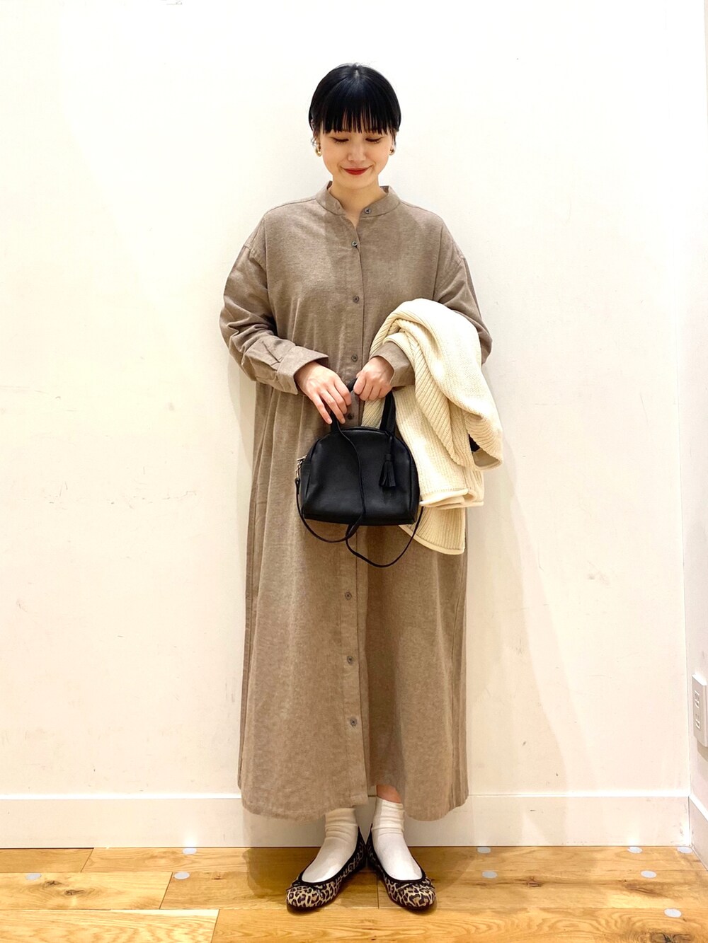 ホワイト系のカーディガン/ボレロ、ベージュ系のワンピース、ブラック系のボストンバッグを着用したレディースの冬コーディネートの3枚目の写真