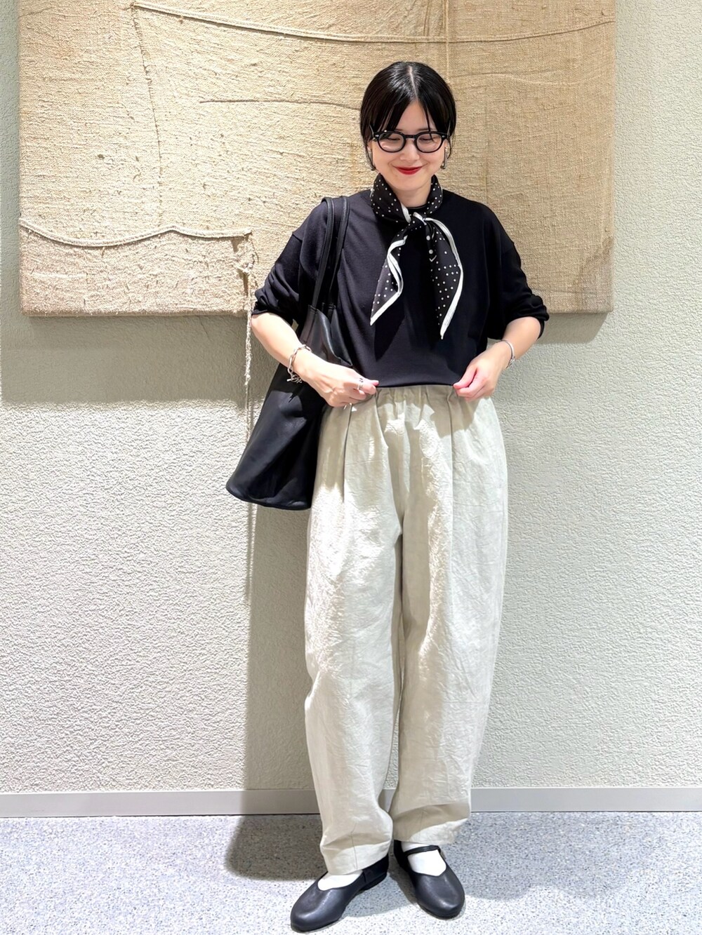 ベージュ系のその他パンツ、ブラック系のトートバッグ、ブラック系のバレエシューズを着用したレディースの秋コーディネートの2枚目の写真