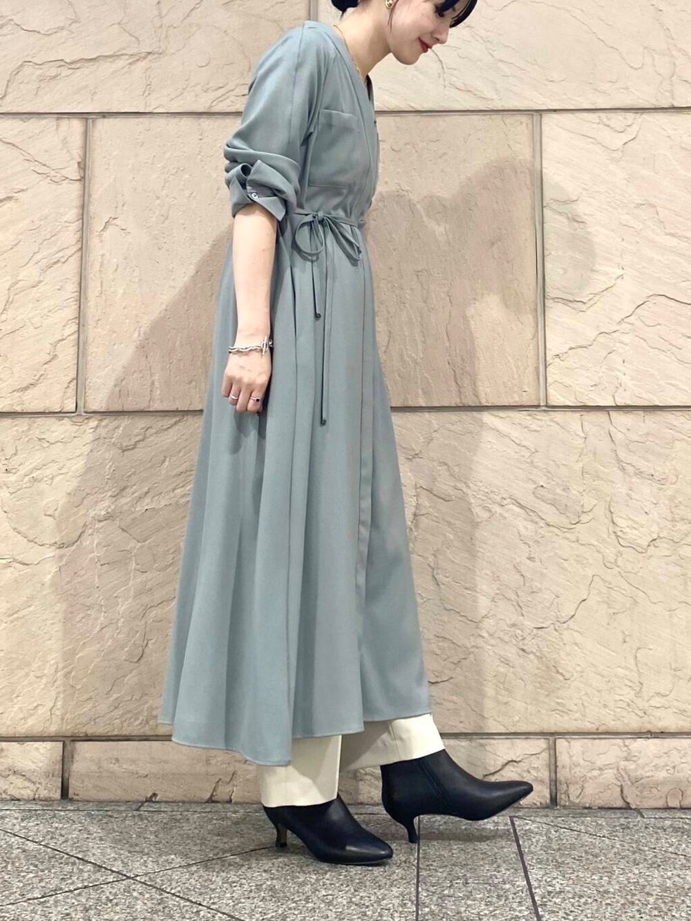 グリーン系のワンピース、ベージュ系のその他パンツ、ブラック系のブーツを着用したレディースの秋コーディネートの6枚目の写真