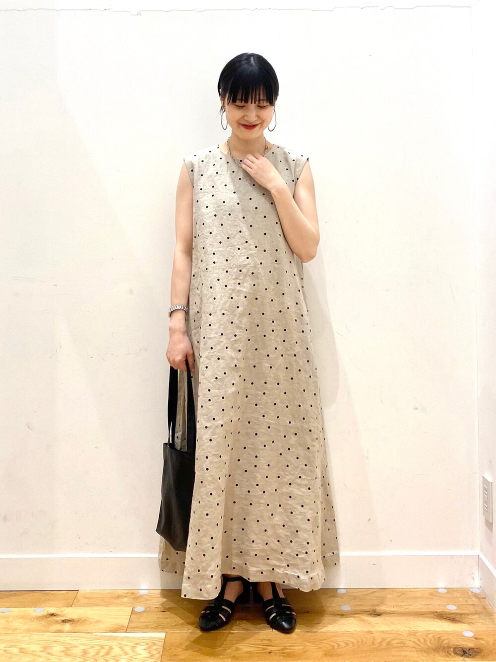 グレー系のカーディガン/ボレロ、ベージュ系のワンピース、ブラック系のトートバッグを着用したレディースの春コーディネートの3枚目の写真