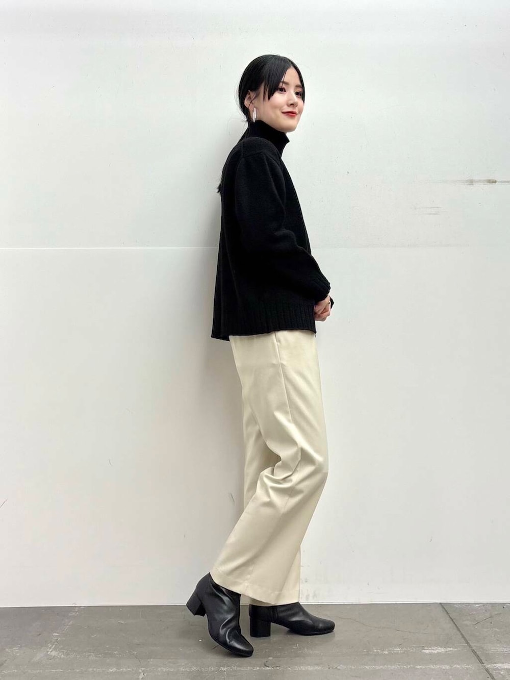 ブラック系のブーツ、イエロー系のステンカラーコート、ホワイト系のその他パンツを着用したレディースの冬コーディネートの5枚目の写真