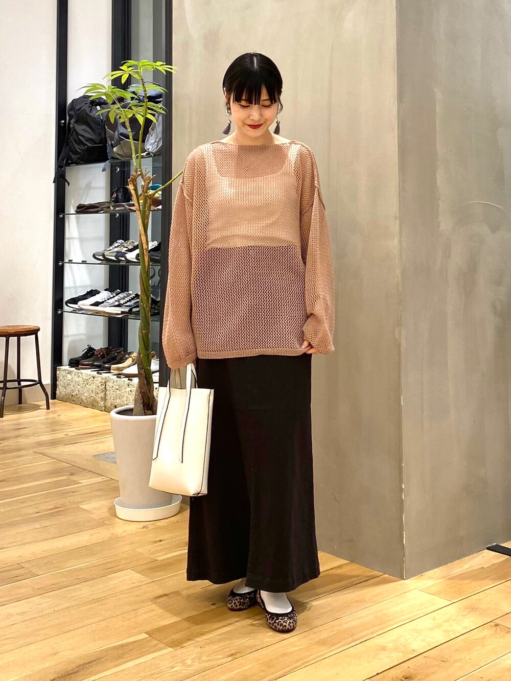 ブラウン系のカーディガン/ボレロ、グレー系のスカート、ホワイト系のショルダーバッグを着用したレディースの春コーディネートの2枚目の写真