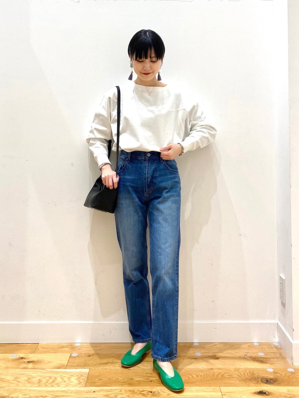 ベージュ系のステンカラーコート、ホワイト系のTシャツ/カットソー、ブルー系のデニムパンツを着用したレディースの春コーディネートの4枚目の写真