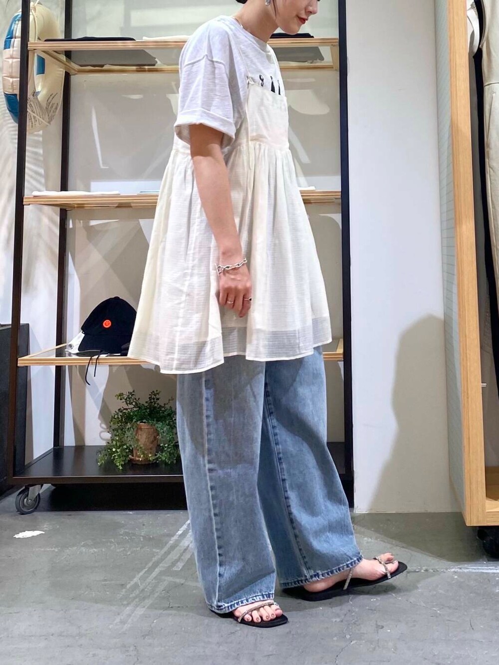 ブルー系のデニムパンツ、グレー系のTシャツ/カットソー、ブラック系のサンダルを着用したレディースの夏コーディネートの7枚目の写真