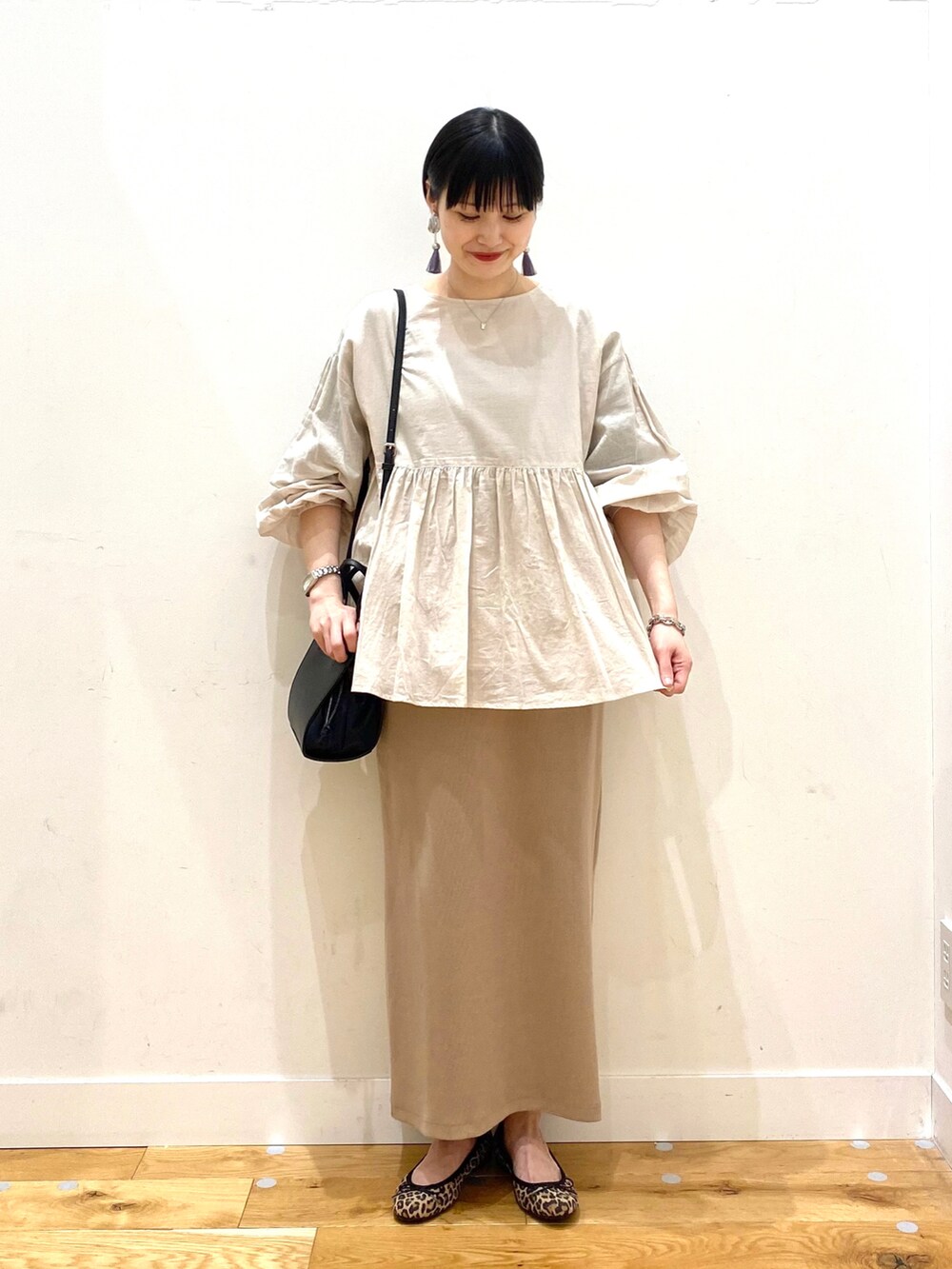 グレー系のシャツ/ブラウス、ベージュ系のスカート、ブラック系のショルダーバッグを着用したレディースの春コーディネートの3枚目の写真