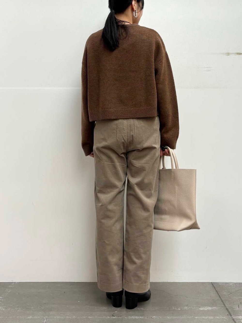 ブラック系のブーツ、ホワイト系のトートバッグ、ベージュ系のその他パンツを着用したレディースの冬コーディネートの5枚目の写真