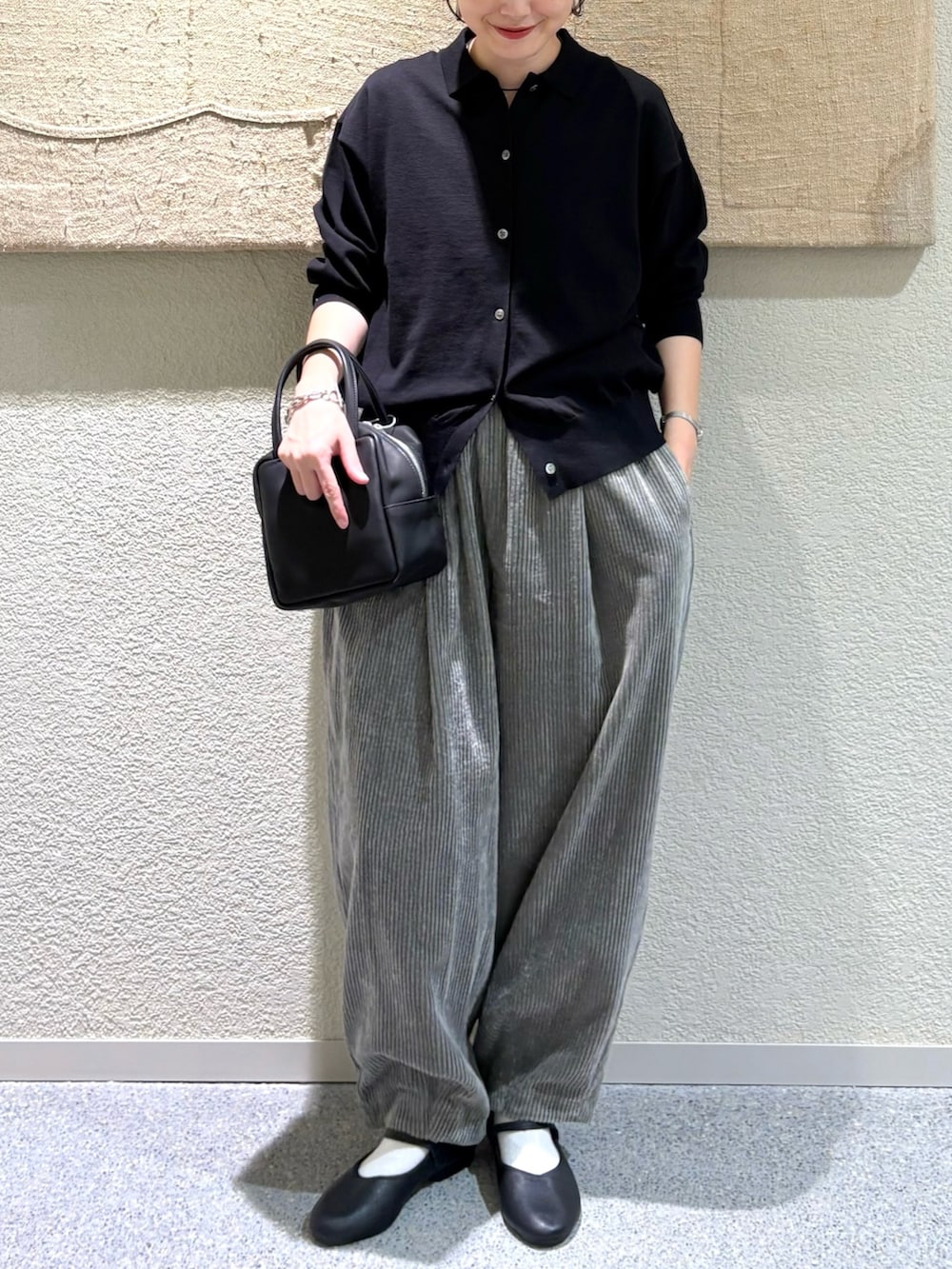 ブラック系のカーディガン/ボレロ、ブラック系のバレエシューズ、ブラック系のトートバッグを着用したレディースの秋コーディネートの4枚目の写真