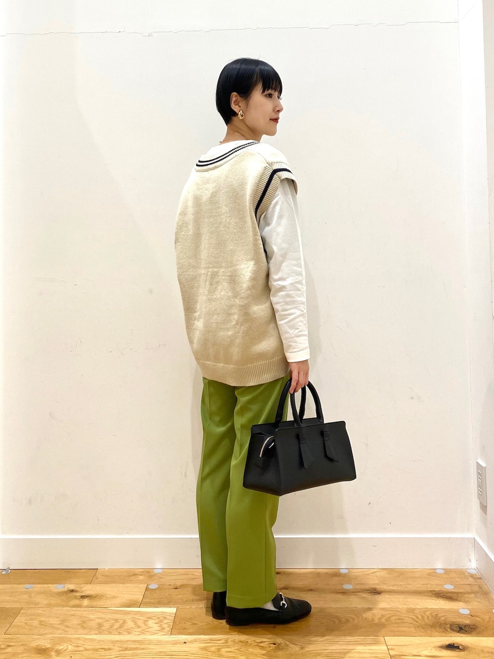 ベージュ系のニット/セーター、グリーン系のその他パンツ、ブラック系のトートバッグを着用したレディースの冬コーディネートの2枚目の写真
