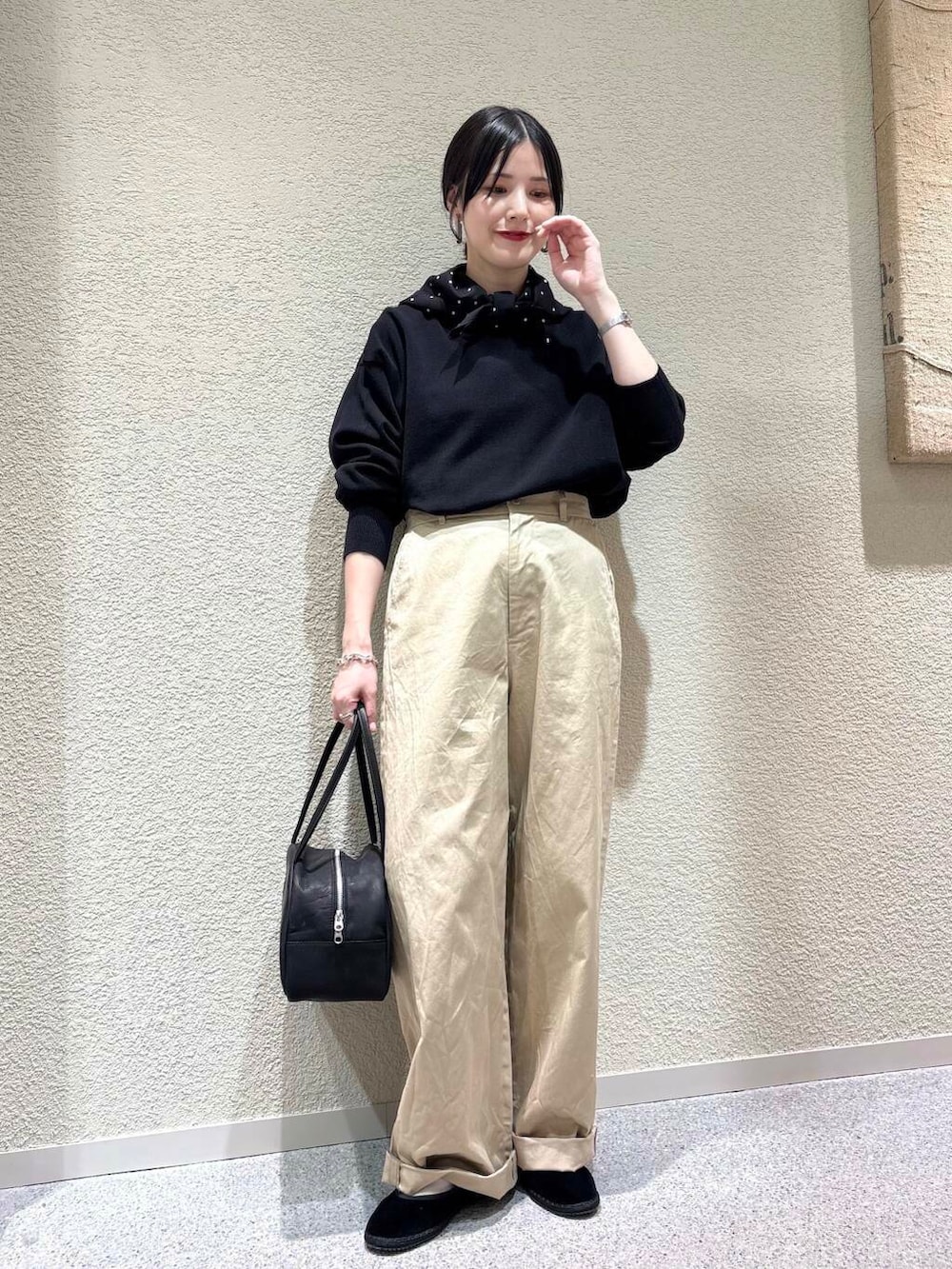 ブラック系のニット/セーター、ベージュ系のその他パンツ、ブラック系のバンダナ/スカーフを着用したレディースの春コーディネートの6枚目の写真