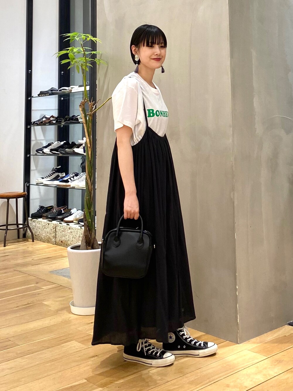 ブラック系のワンピース、ブラック系のショルダーバッグ、ブラック系のスニーカーを着用したレディースの春コーディネートの3枚目の写真