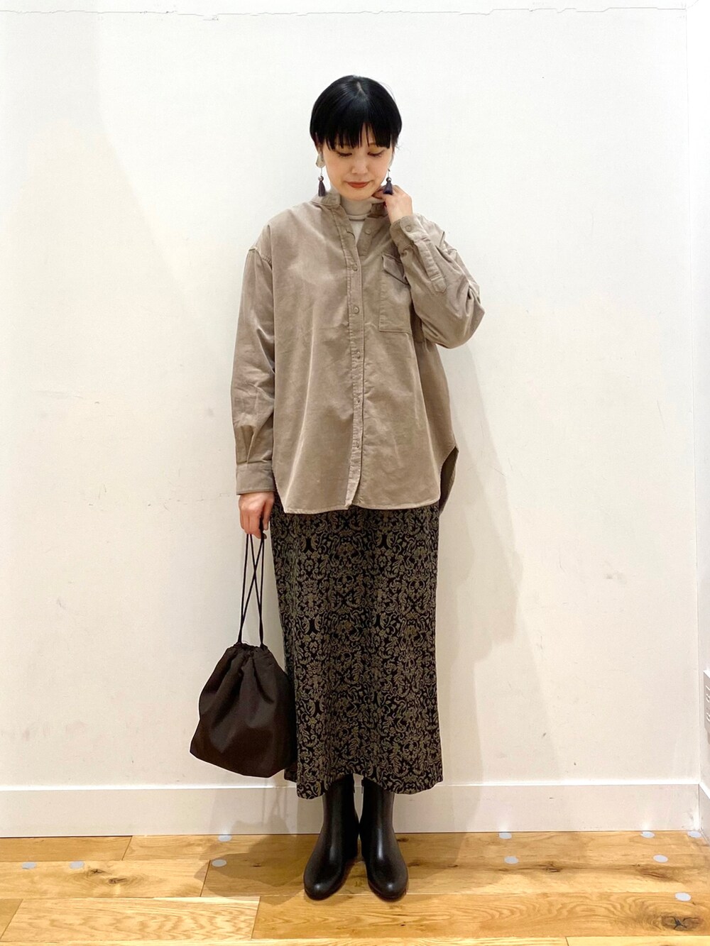 ベージュ系のシャツ/ブラウス、グレー系のTシャツ/カットソー、ブラック系のスカートを着用したレディースの秋コーディネートの2枚目の写真