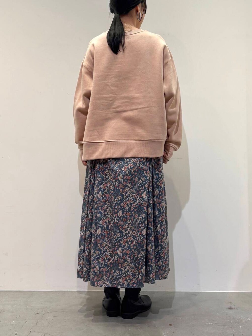 ブラック系のブーツ、ブルー系のスカート、ピンク系のスウェットを着用したレディースの冬コーディネートの5枚目の写真