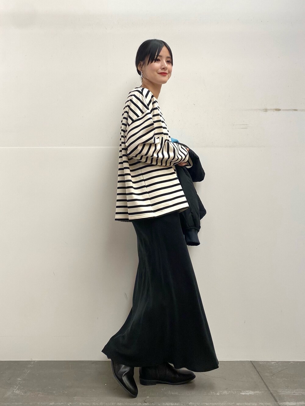 ブラック系のブルゾン、ホワイト系のTシャツ/カットソー、ブラック系のスカートを着用したレディースの秋コーディネートの5枚目の写真