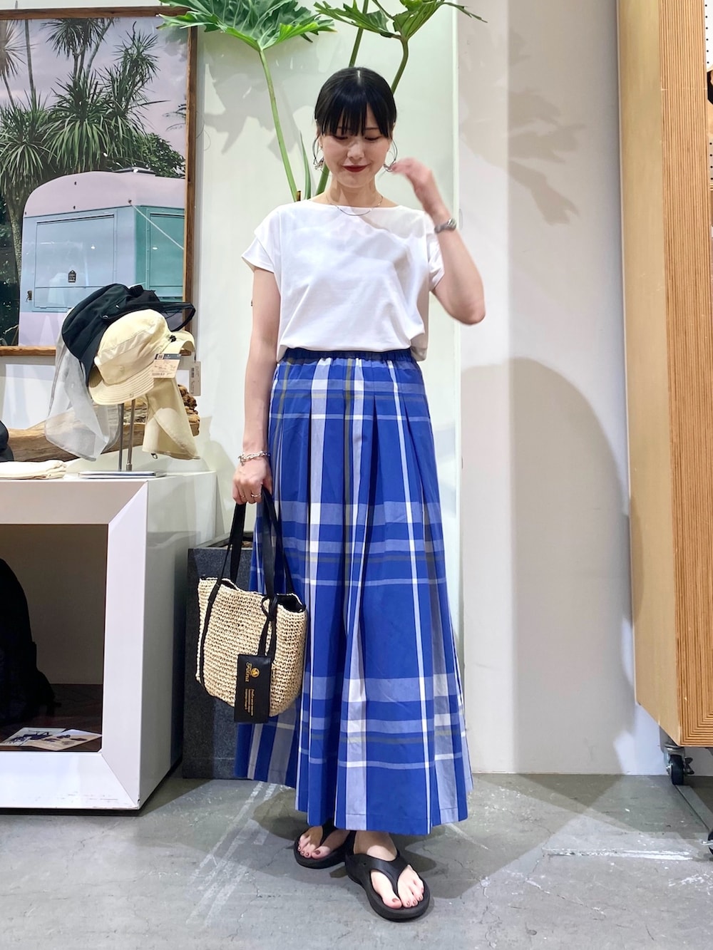 ホワイト系のTシャツ/カットソー、ブルー系のスカート、ベージュ系のトートバッグを着用したレディースの夏コーディネートの2枚目の写真