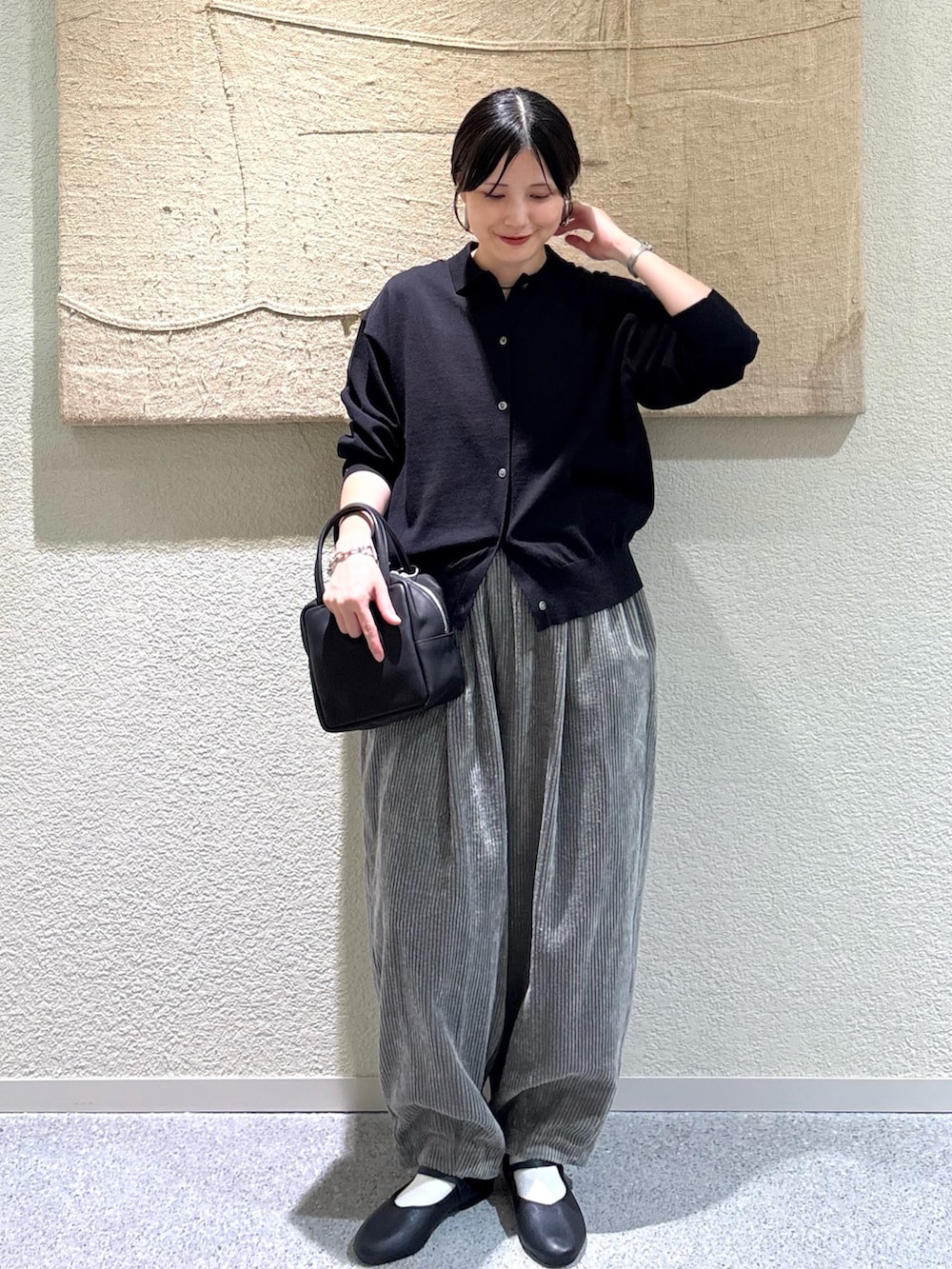 ブラック系のカーディガン/ボレロ、ブラック系のバレエシューズ、ブラック系のトートバッグを着用したレディースの秋コーディネートの6枚目の写真