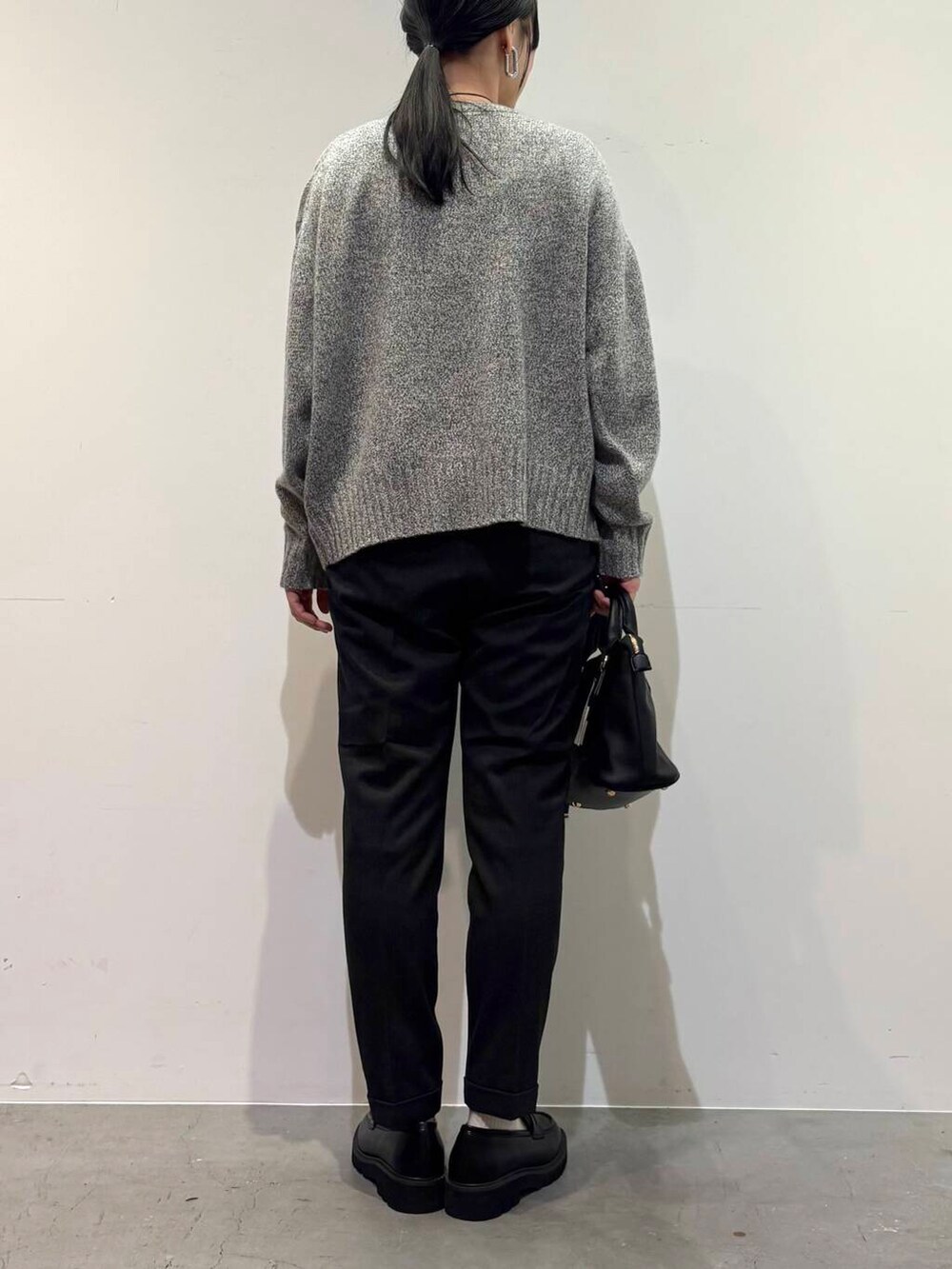 グレー系のニット/セーター、ブラック系のボストンバッグ、グレー系のその他パンツを着用したレディースの冬コーディネートの5枚目の写真