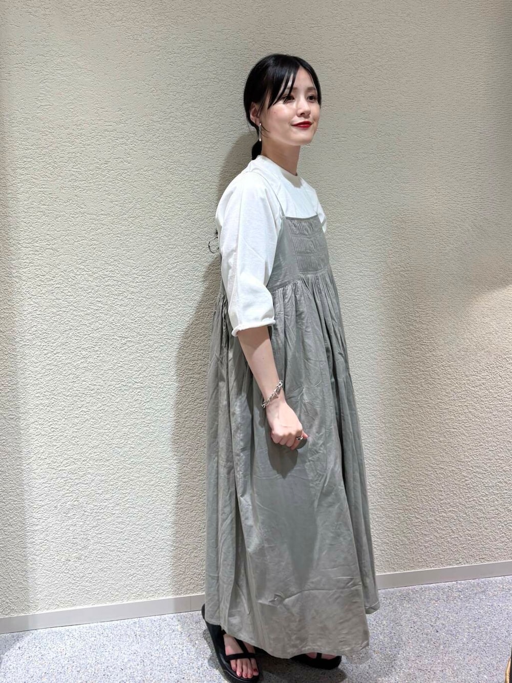 グリーン系のワンピース、ホワイト系のTシャツ/カットソーを着用したレディースの夏コーディネートの2枚目の写真