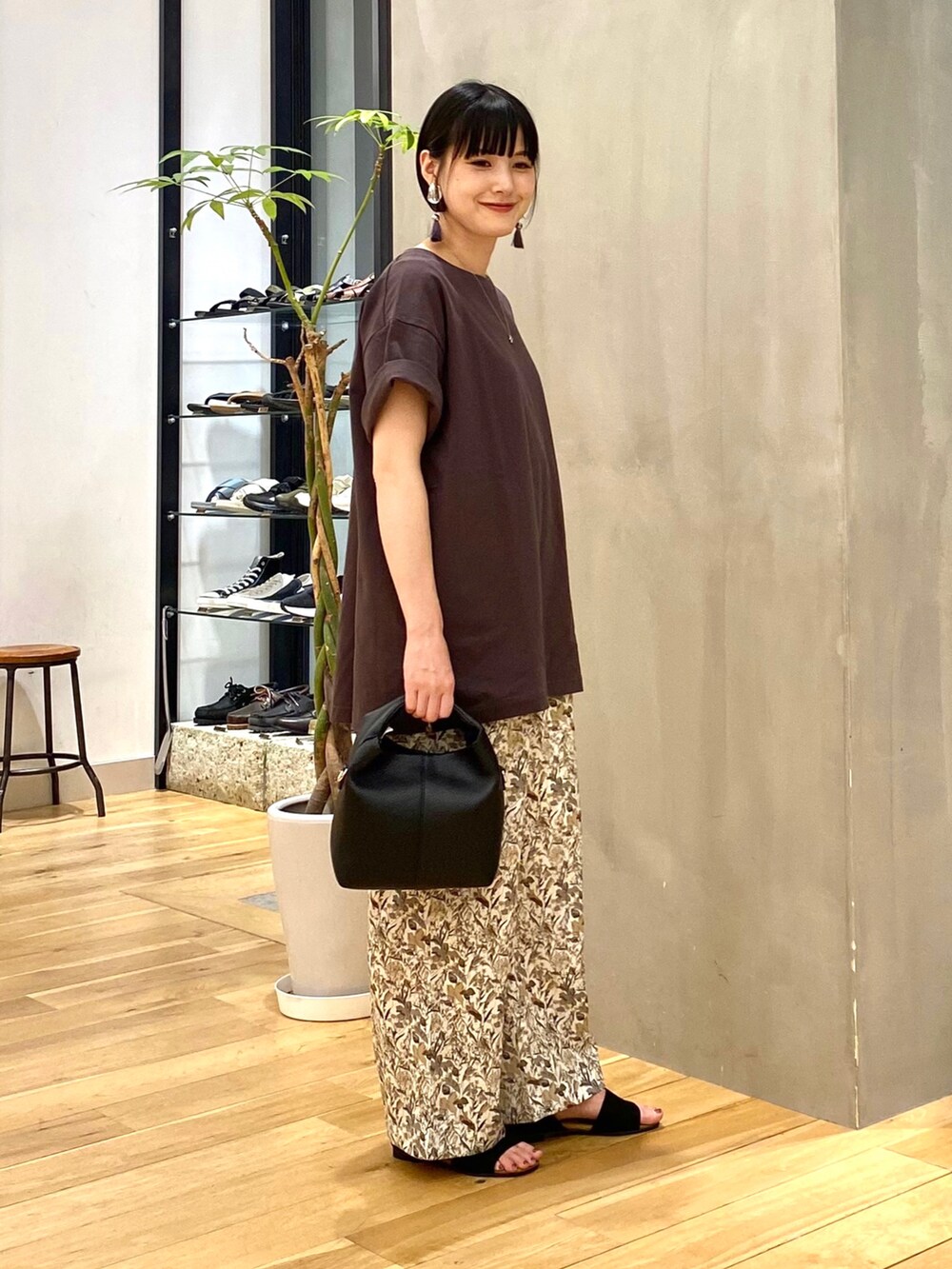 グレー系のTシャツ/カットソー、ホワイト系のその他パンツ、ブラック系のハンドバッグを着用したレディースの夏コーディネートの3枚目の写真