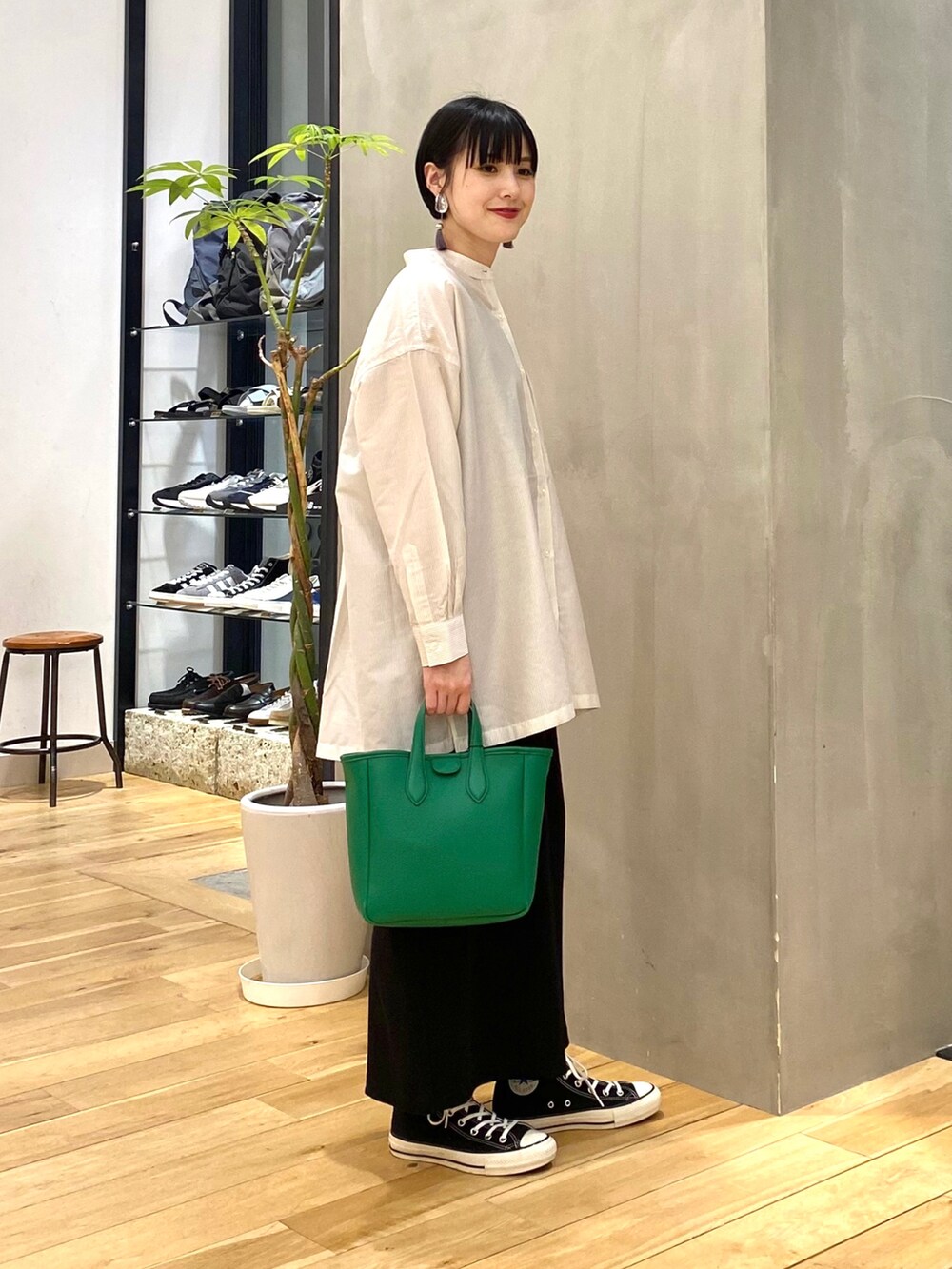 ホワイト系のシャツ/ブラウス、ブラック系のスカート、ブラック系のスニーカーを着用したレディースの春コーディネートの3枚目の写真
