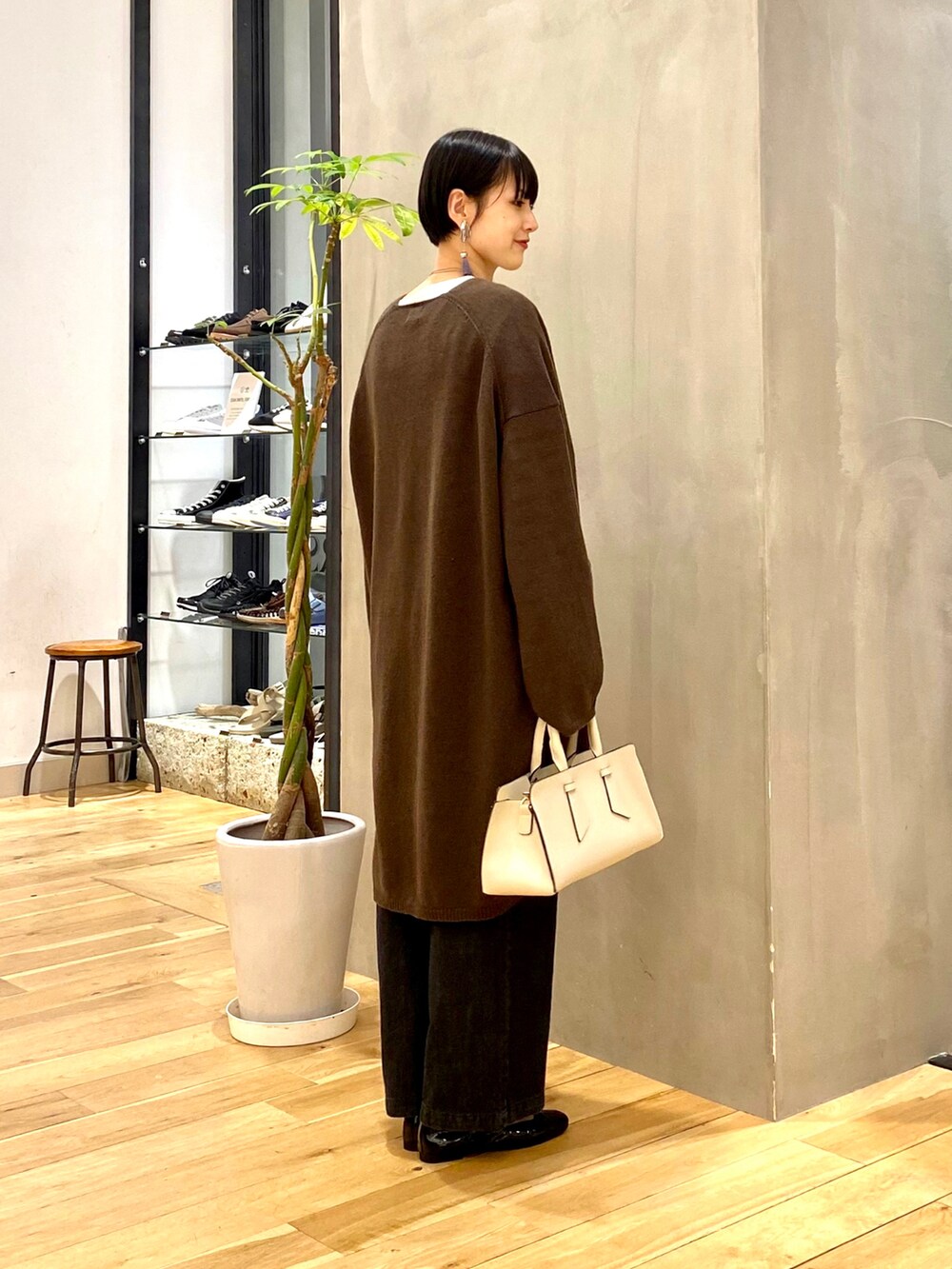 ブラウン系のカーディガン/ボレロ、ブルー系のTシャツ/カットソー、ブラック系のデニムパンツを着用したレディースの秋コーディネートの2枚目の写真