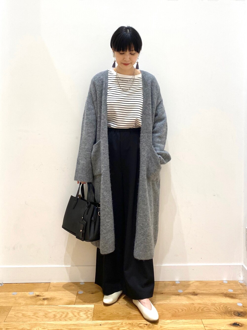 グレー系のカーディガン/ボレロ、ホワイト系のTシャツ/カットソー、ブラック系のその他パンツを着用したレディースの秋コーディネートの2枚目の写真