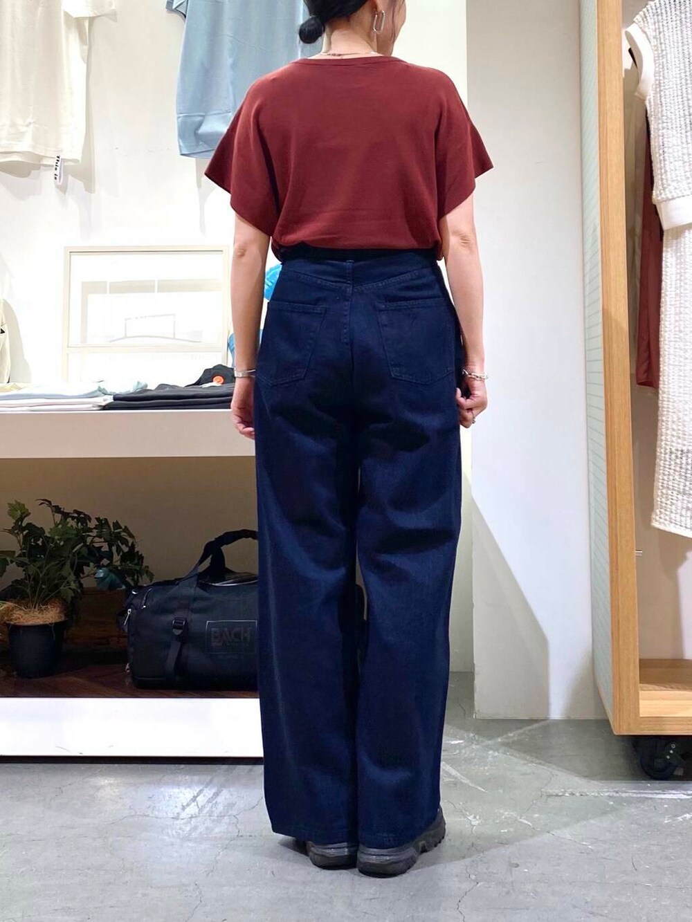 レッド系のニット/セーター、ブルー系のデニムパンツを着用したレディースの夏コーディネートの7枚目の写真