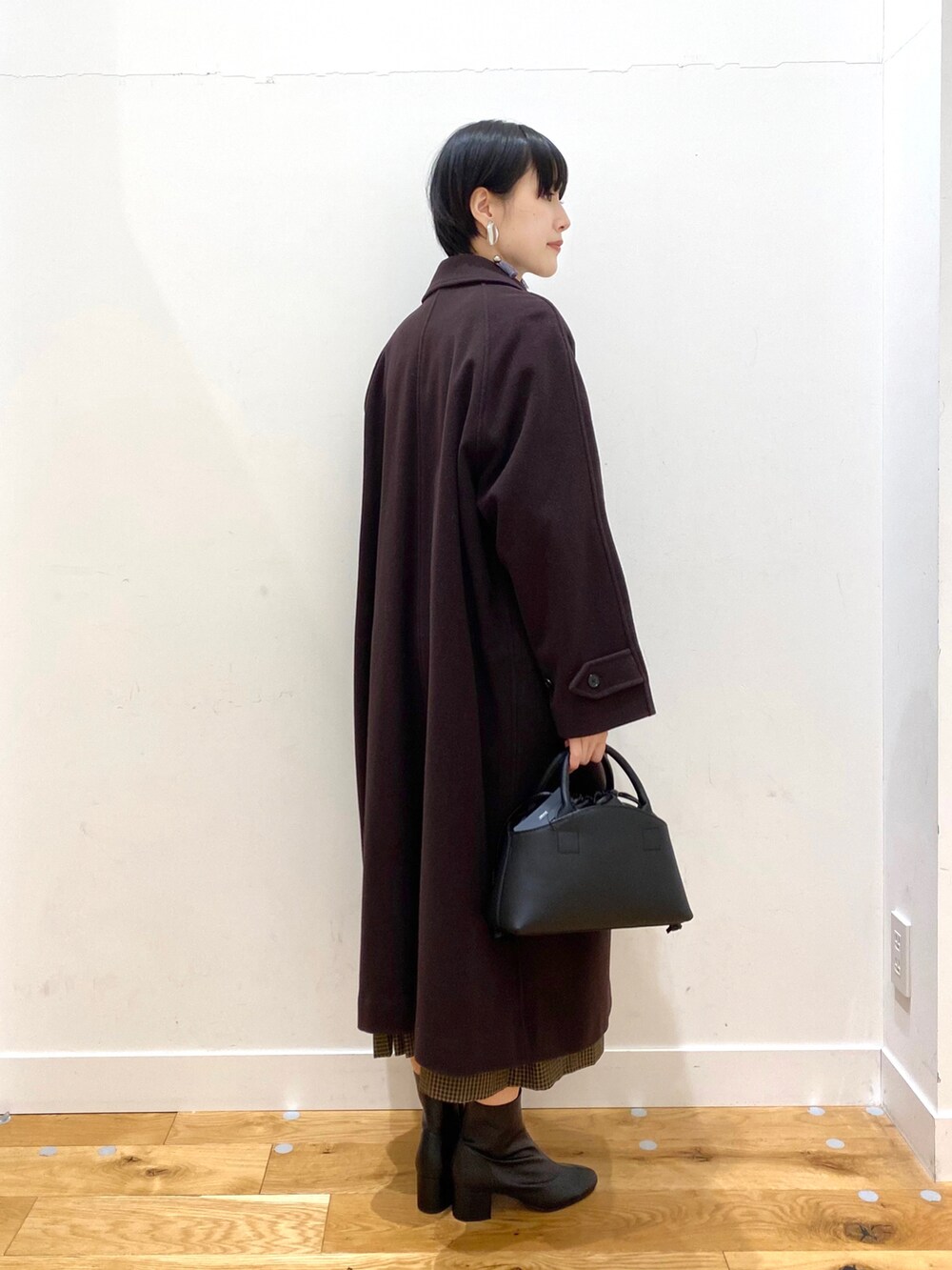 ブラウン系のステンカラーコート、その他のワンピース、ブラック系のショルダーバッグを着用したレディースの秋コーディネートの3枚目の写真