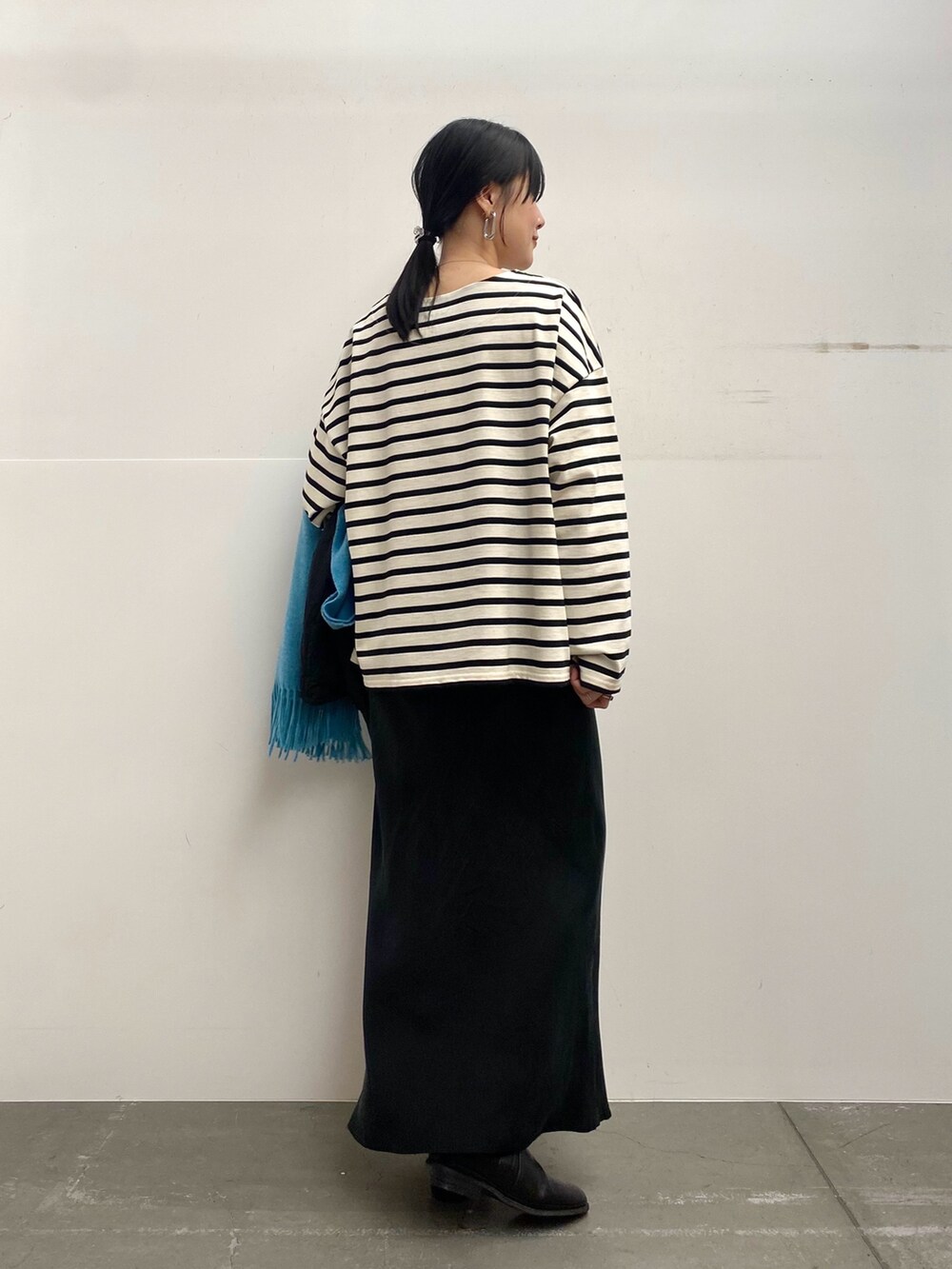 ブラック系のブルゾン、ホワイト系のTシャツ/カットソー、ブラック系のスカートを着用したレディースの秋コーディネートの6枚目の写真