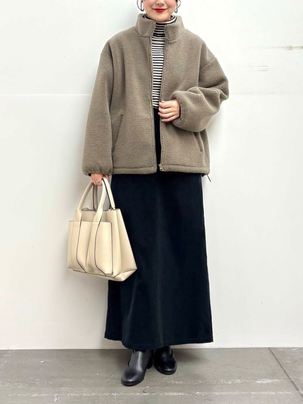 ブラック系のブーツ、グレー系のブルゾン、その他のニット/セーターを着用したレディースの冬コーディネートの4枚目の写真