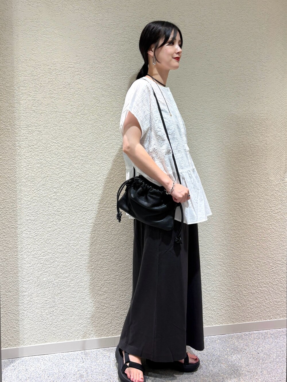 ホワイト系のシャツ/ブラウス、グレー系のスカートを着用したレディースの夏コーディネートの2枚目の写真