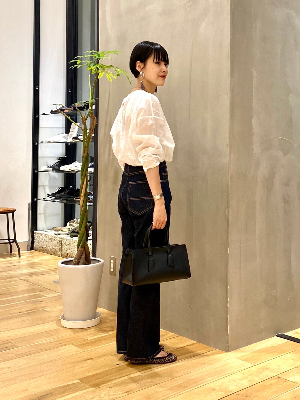 ブラウン系のカーディガン/ボレロ、ホワイト系のTシャツ/カットソー、ブルー系のデニムパンツを着用したレディースの秋コーディネートの4枚目の写真