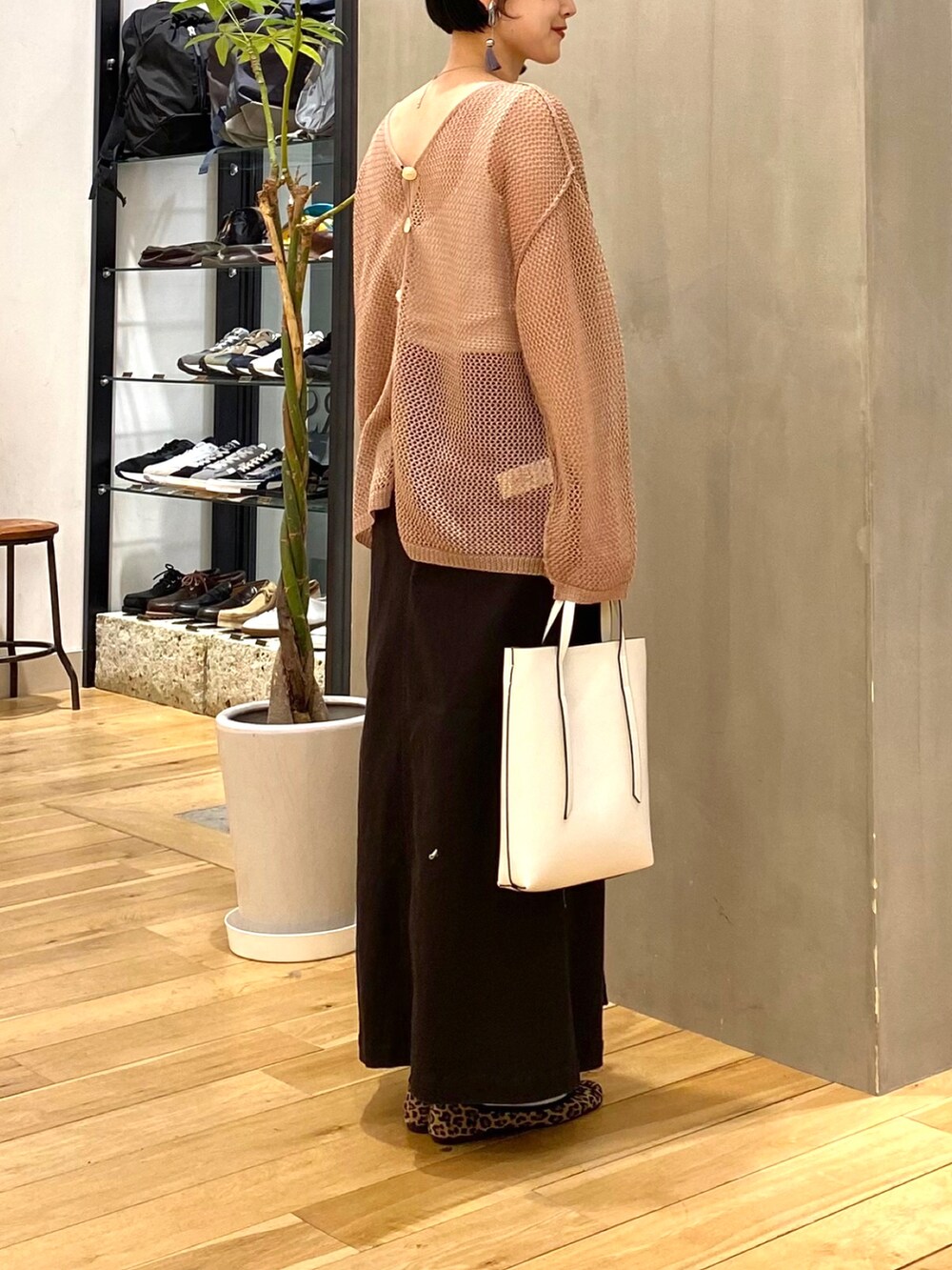 ブラウン系のカーディガン/ボレロ、グレー系のスカート、ホワイト系のショルダーバッグを着用したレディースの春コーディネートの5枚目の写真