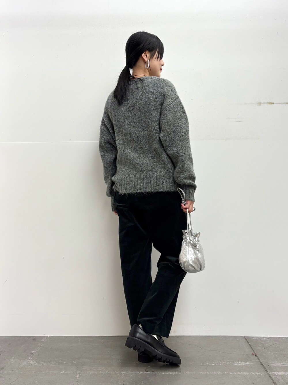 グレー系のニット/セーター、ブラック系のその他パンツ、シルバー系のショルダーバッグを着用したレディースの冬コーディネートの4枚目の写真