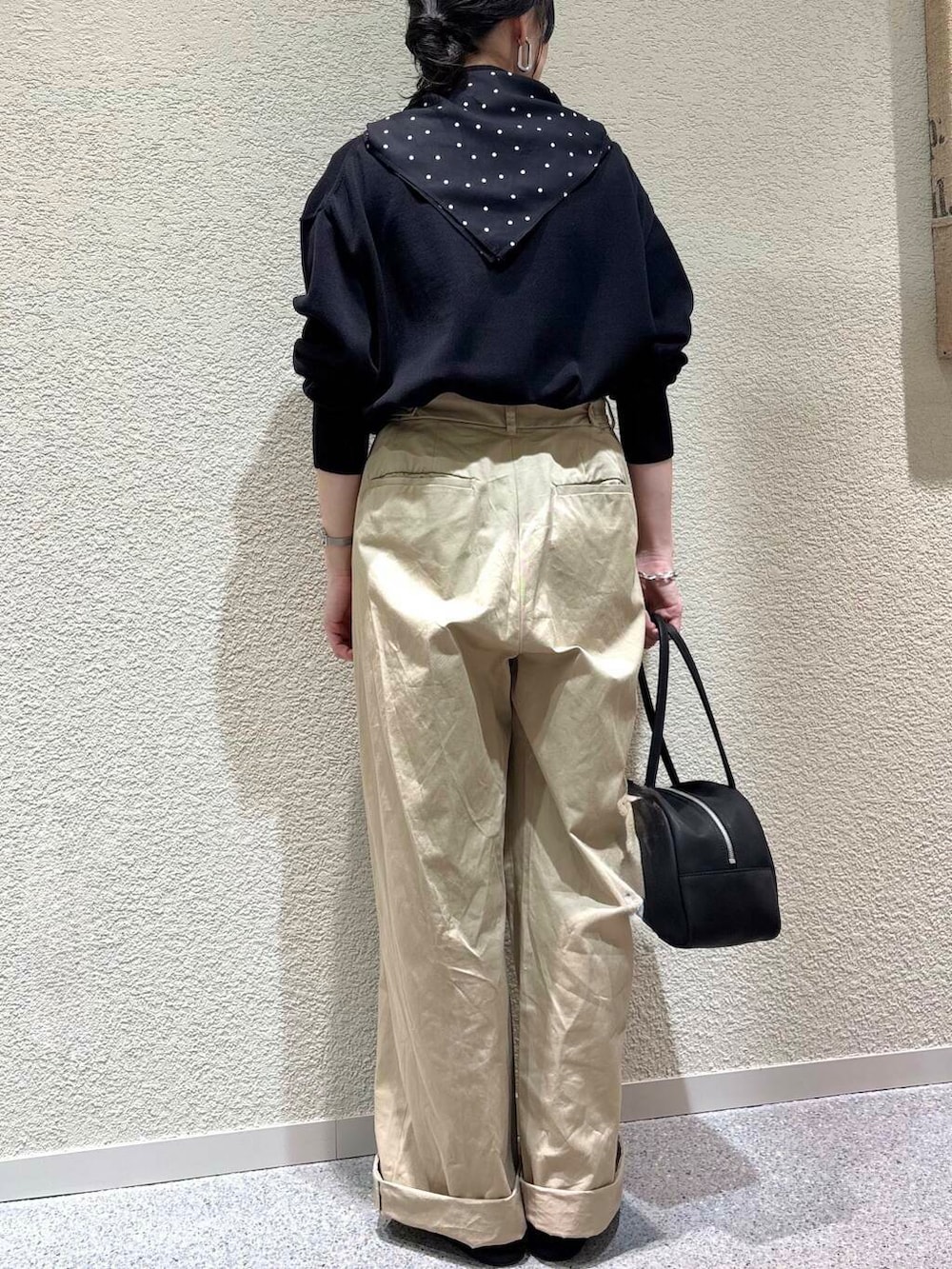 ブラック系のニット/セーター、ベージュ系のその他パンツ、ブラック系のバンダナ/スカーフを着用したレディースの春コーディネートの5枚目の写真