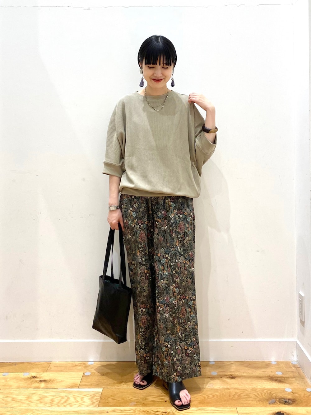 ベージュ系のTシャツ/カットソー、ブラック系のその他パンツ、ブラック系のトートバッグを着用したレディースの春コーディネートの2枚目の写真