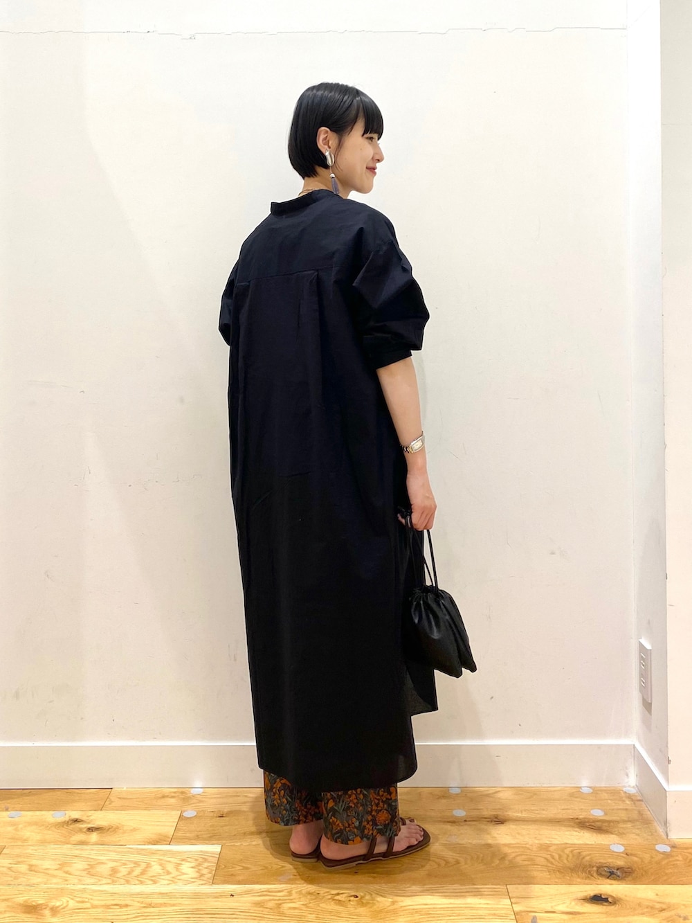 ブラック系のワンピース、オレンジ系のその他パンツ、ブラック系のショルダーバッグを着用したレディースの春コーディネートの3枚目の写真