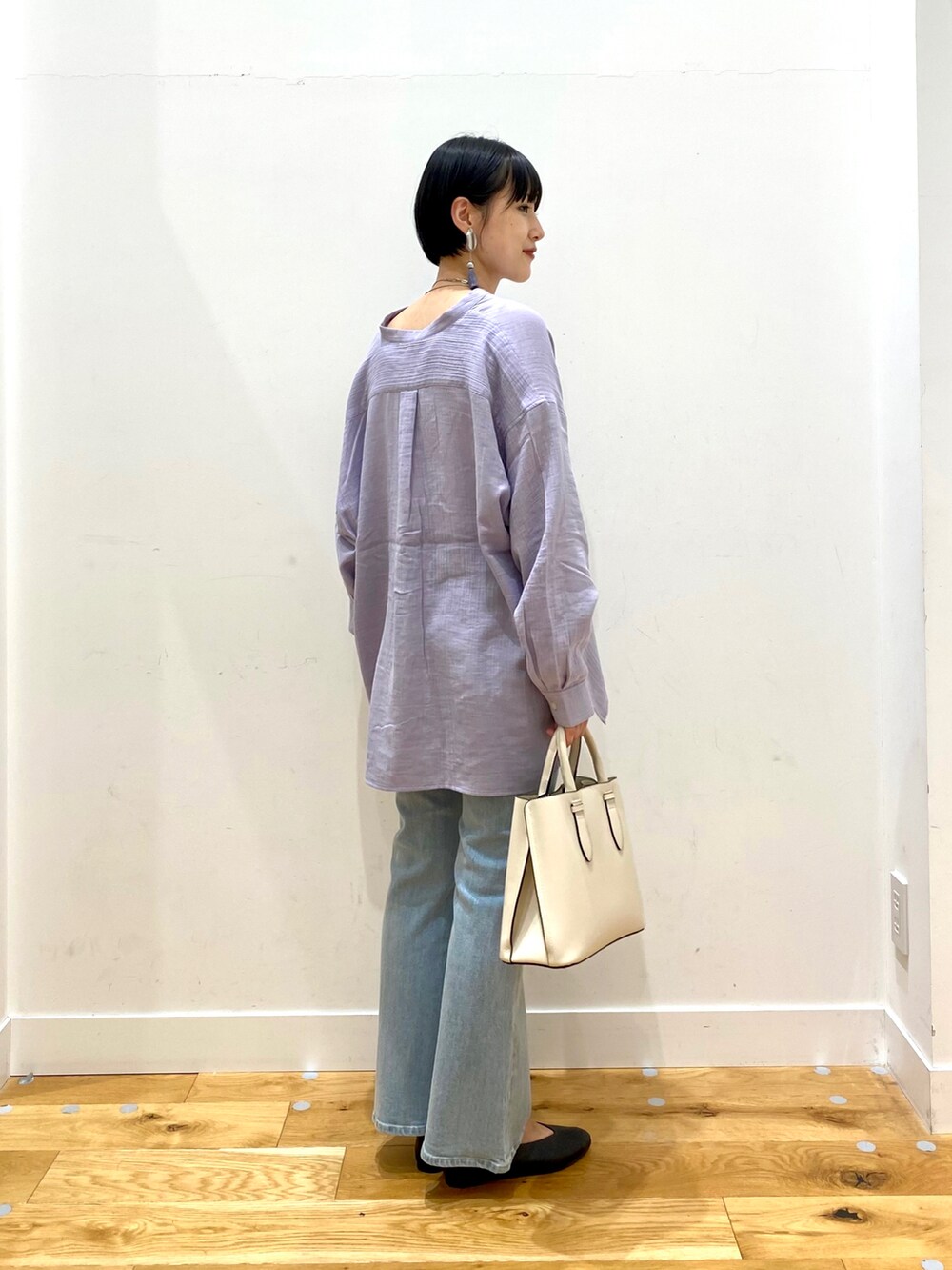 パープル系のシャツ/ブラウス、ブルー系のデニムパンツ、ホワイト系のトートバッグを着用したレディースの秋コーディネートの3枚目の写真