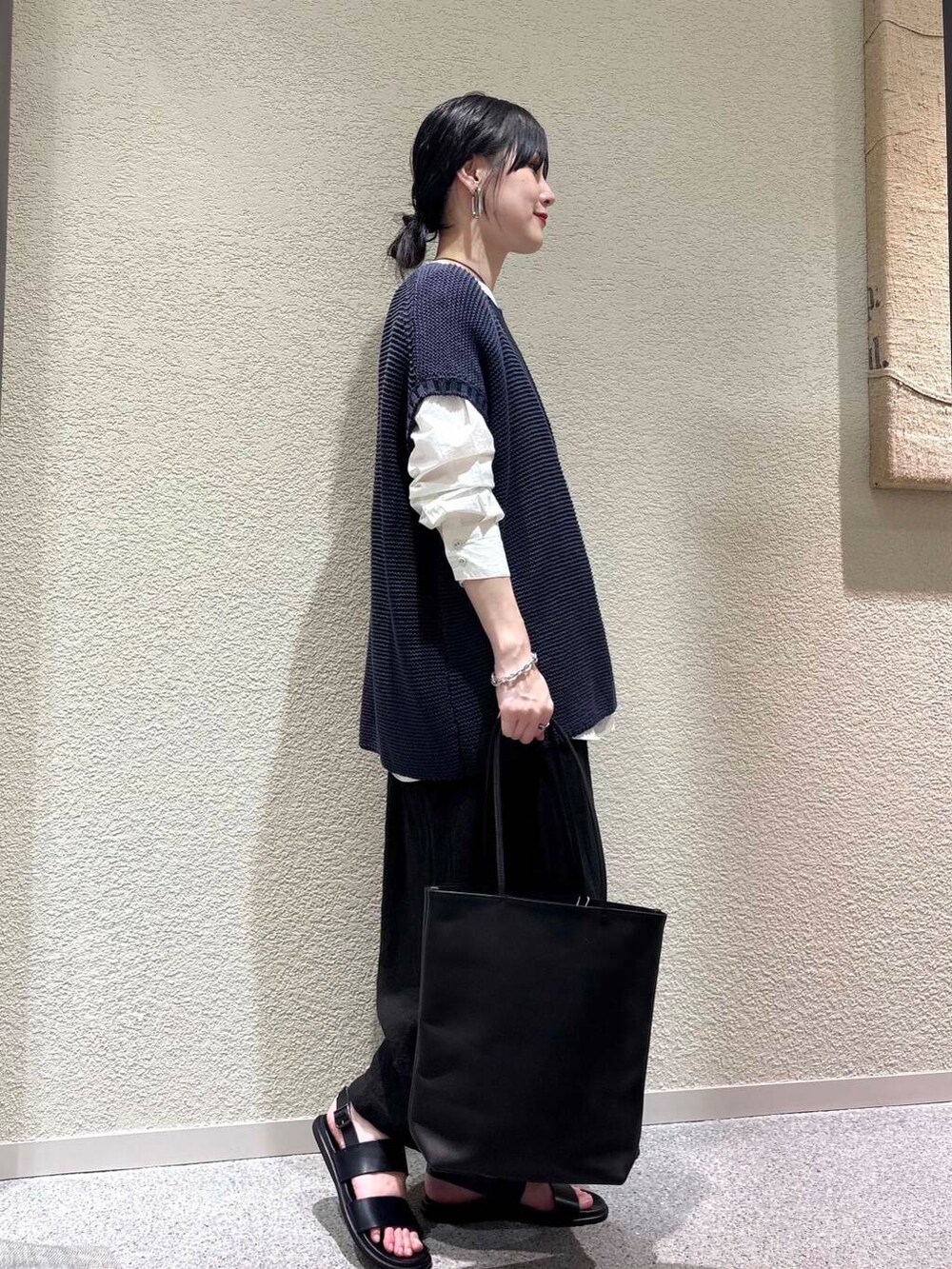 ホワイト系のシャツ/ブラウス、ブルー系のベスト、ブラック系のスカートを着用したレディースの春コーディネートの2枚目の写真