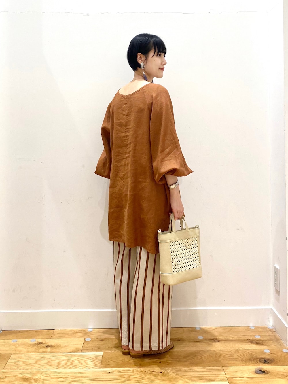 ブラウン系のシャツ/ブラウス、ホワイト系のその他パンツ、イエロー系のサンダルを着用したレディースの春コーディネートの3枚目の写真